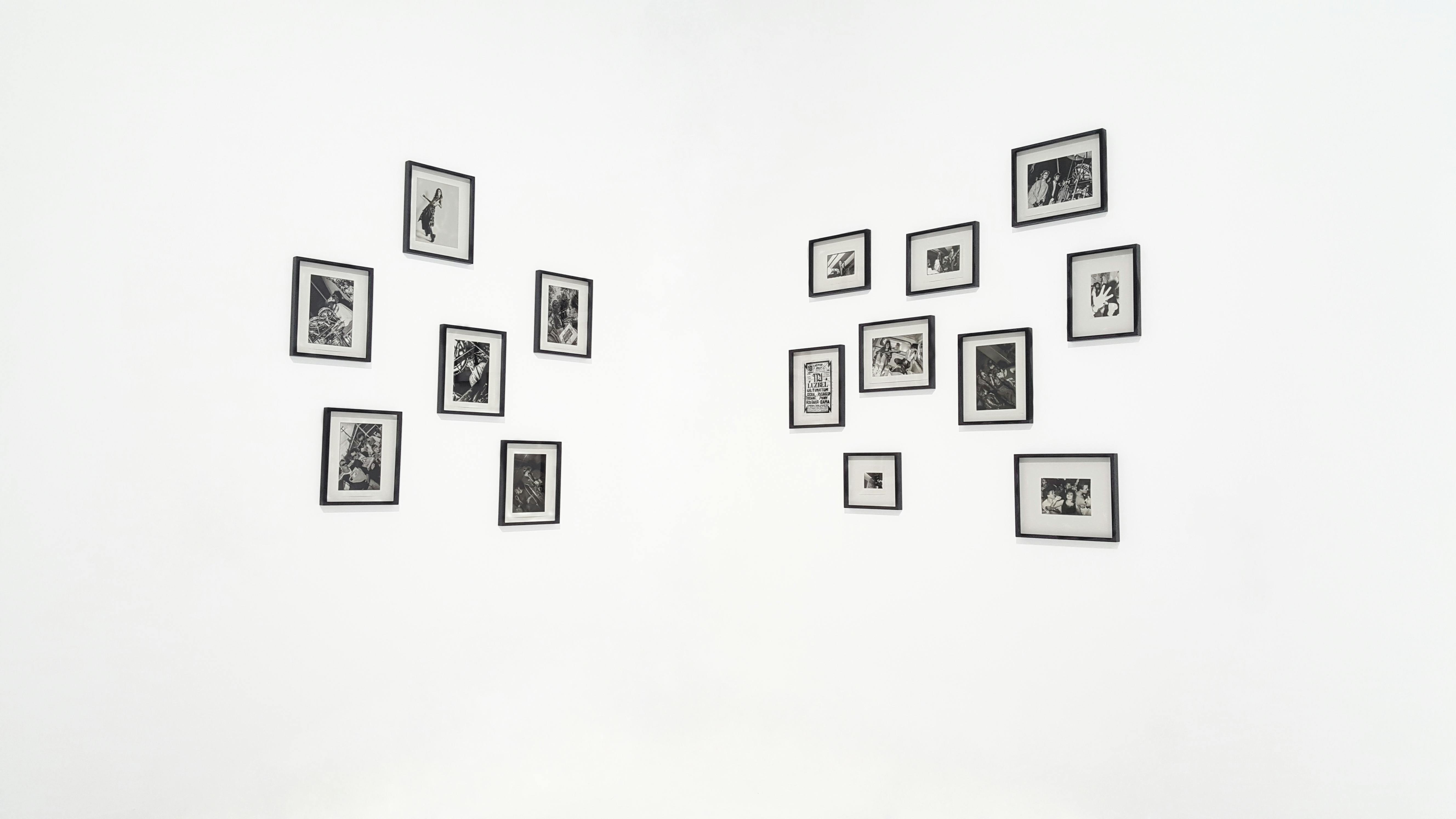 Minimalist display of black and white photos in gallery setting.